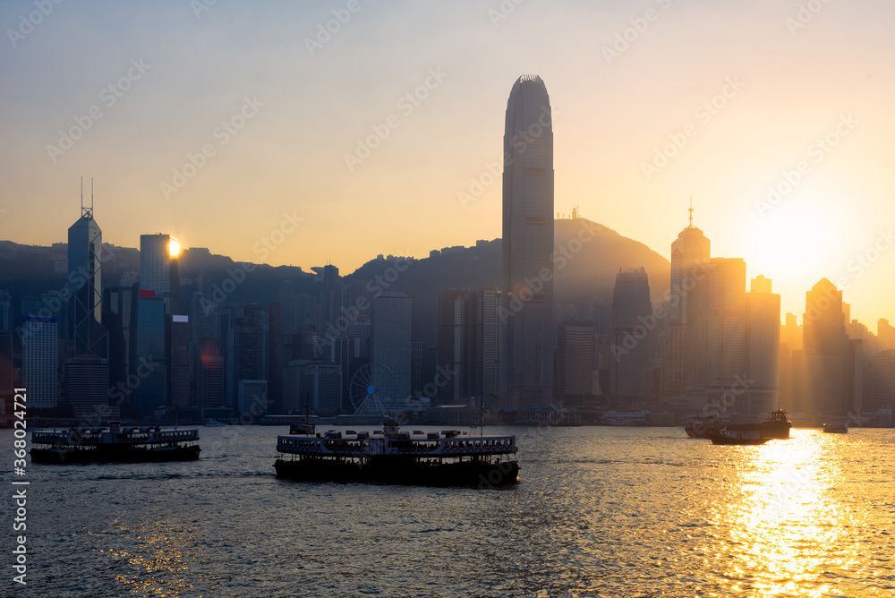 Hong kong traditional wooden chinese boat for tourist service in victoria harbor at sunset view from Kowloon side at Hong Kong. Hong kong traditional wooden chinese boat for tourist service in victoria harbor at sunset view from Kowloon side at Hong Kong.