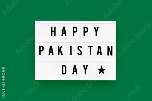 HAPPY PAKISTAN DAY written in a lightbox on a green background. Independence day date. Top view