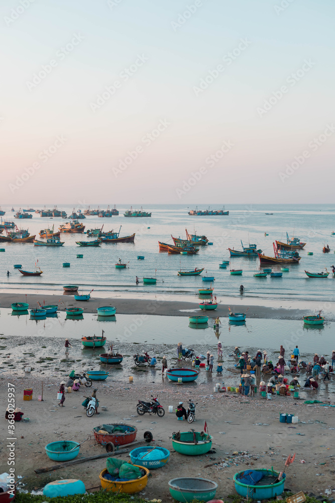 MUI NE / VIETNAM - December 28, 2019 :  view on Fishing village and traditional fishing boat with hundreds boats anchored ( fishing harbour market)