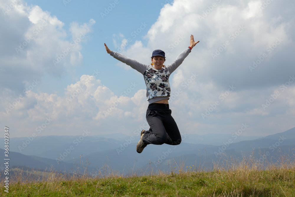 girl jumping on the background of the mountains and clouds sky girl jumping on the background of the mountains and clouds sky