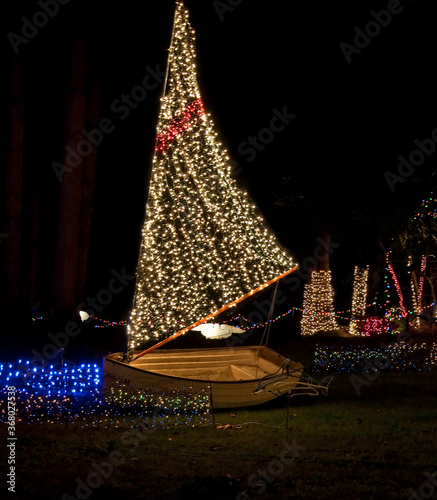 Holiday image is a sailboat with Christmas lights at night for a holiday display.