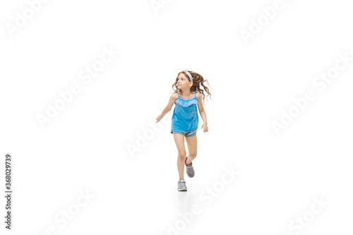 Happy kids, little and emotional caucasian girl jumping and running isolated on white background. Look happy, cheerful, sincere. Copyspace for ad. Childhood, education, happiness concept.