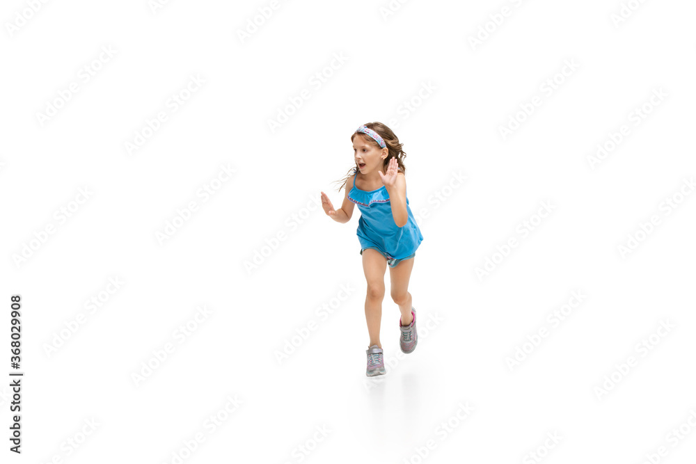 Happy kids, little and emotional caucasian girl jumping and running isolated on white background. Look happy, cheerful, sincere. Copyspace for ad. Childhood, education, happiness concept. Happy kids, little and emotional caucasian girl jumping and running isolated on white background. Look happy, cheerful, sincere. Copyspace for ad. Childhood, education, happiness concept.