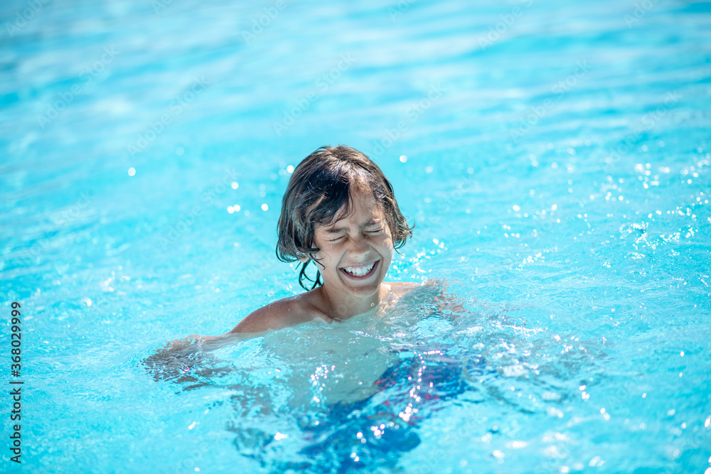Boy in water smiling with closed eyes
