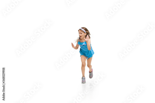 Happy kids, little and emotional caucasian girl jumping and running isolated on white background. Look happy, cheerful, sincere. Copyspace for ad. Childhood, education, happiness concept.