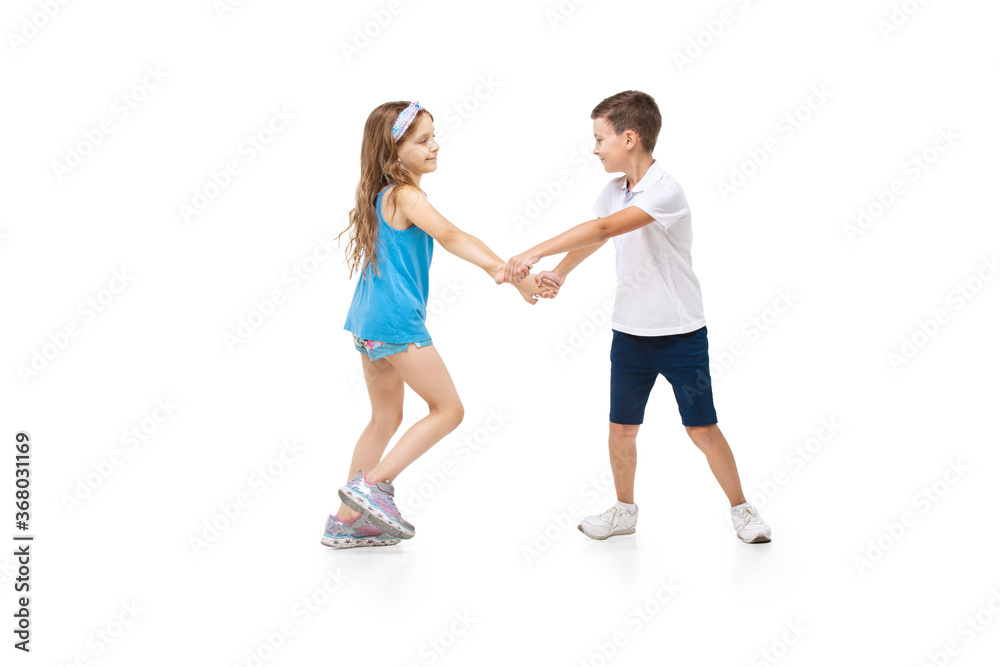 Happy kids, little and emotional caucasian boy and girl jumping and running isolated on white background. Look happy, cheerful, sincere. Copyspace for ad. Childhood, education, happiness concept. Happy kids, little and emotional caucasian boy and girl jumping and running isolated on white background. Look happy, cheerful, sincere. Copyspace for ad. Childhood, education, happiness concept.