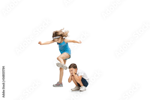Happy kids, little and emotional caucasian boy and girl jumping and running isolated on white background. Look happy, cheerful, sincere. Copyspace for ad. Childhood, education, happiness concept. © master1305