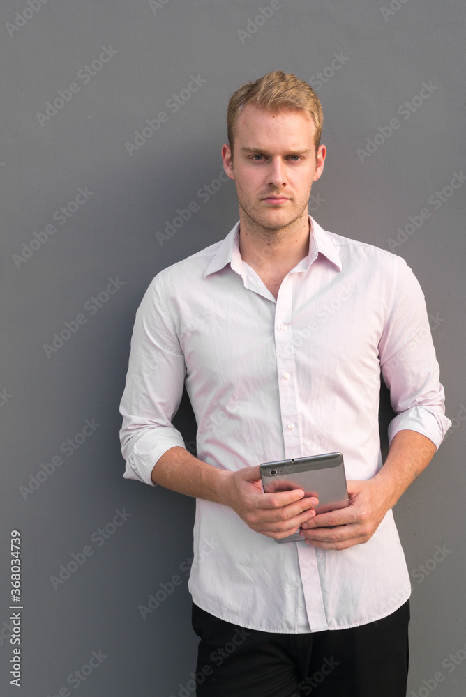 Portrait of young handsome businessman with blond hair
