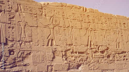 Luxor Egypt karnak temple behind big wall craved with hieroglyphics of god and pharaoh large size