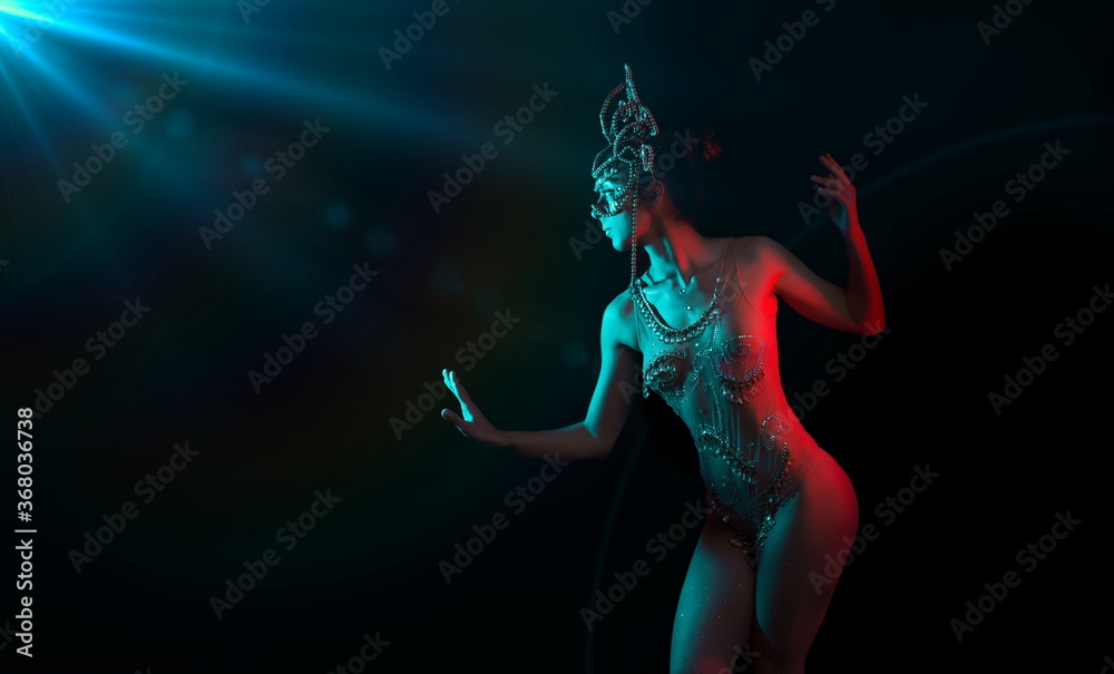 Indian goddess illuminated by blue flare and red light on black background