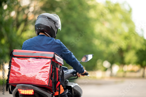 The staff prepares the delivery box on the motorcycle for delivery to customers.