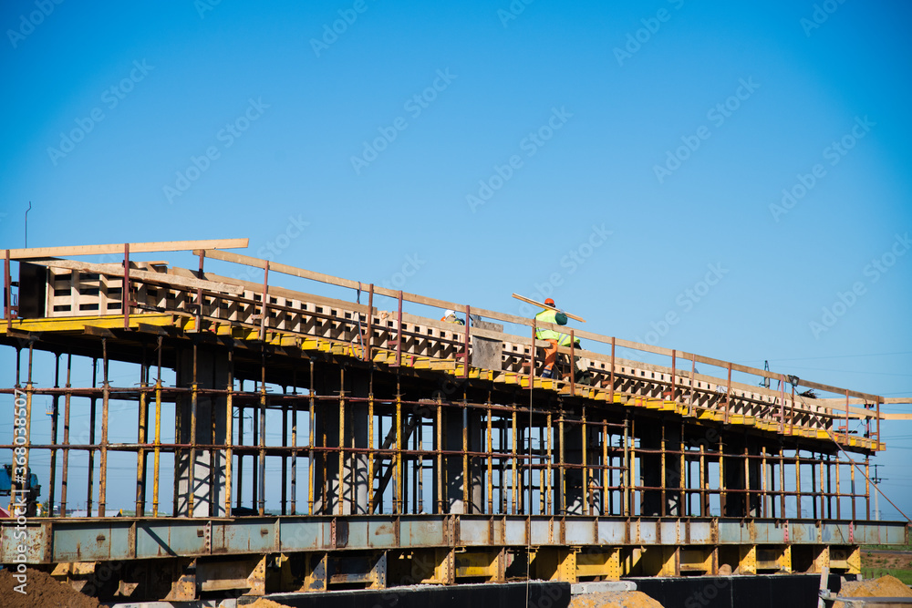Obraz premium Construction of the interchange of a road bridge across the river