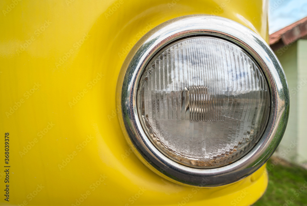 Runder Scheinwerfer eines alten gelben Fahrzeugs