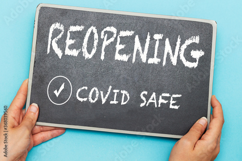 Photos hands holding chalkboard with notice reopening covid safe