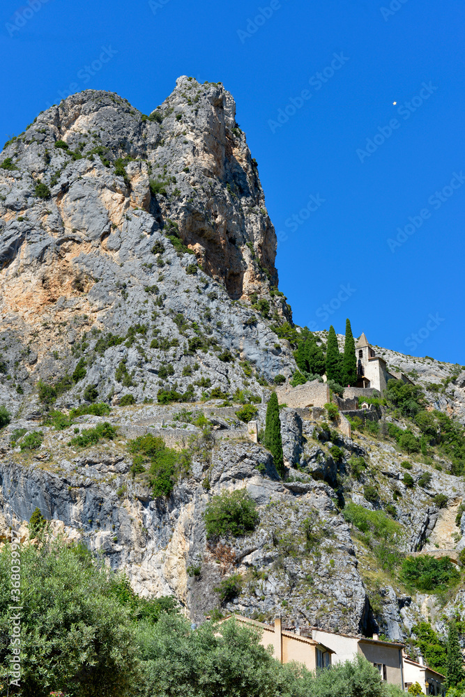Moustiers-Sainte-Marie and Notre-Dame-de-Beavoir chapel in the mountain. Moustiers-Sainte-Marie is a commune in the Alpes-de-Haute-Provence department in southeastern France