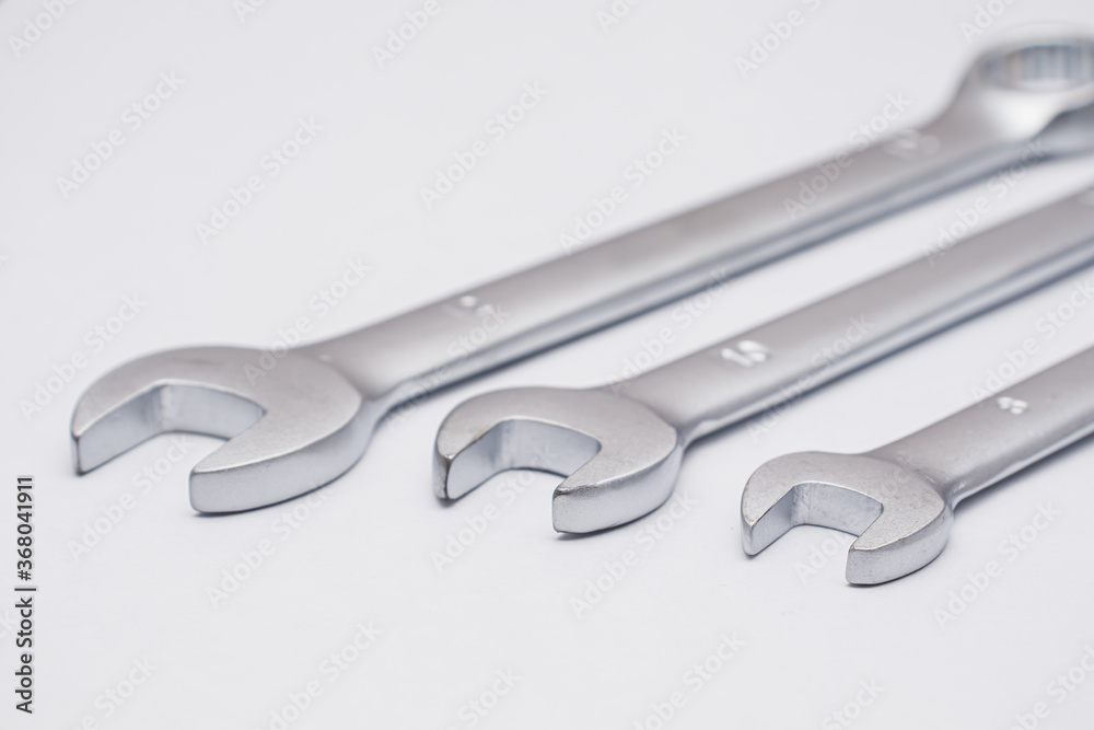 Wrenches close-up on a white background. Chrome plated wrenches. Wrenches of different sizes and types.. Wrenches close-up on a white background. Chrome plated wrenches. Wrenches of different sizes and types..