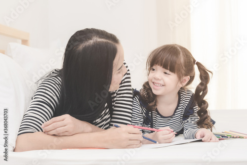 Happy family in the bedroom,Asian mother teaching her daughter child to learning for preschool. Photo design for family, children and happy people concept.