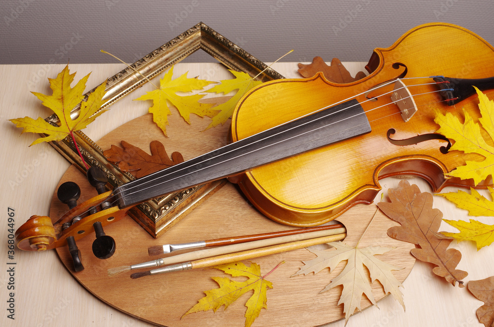 Fototapeta premium Violin, bow, art palette, brushes and autumn maple leaves.