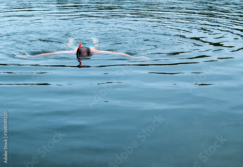 Man swimming in the sea wearing a mask.