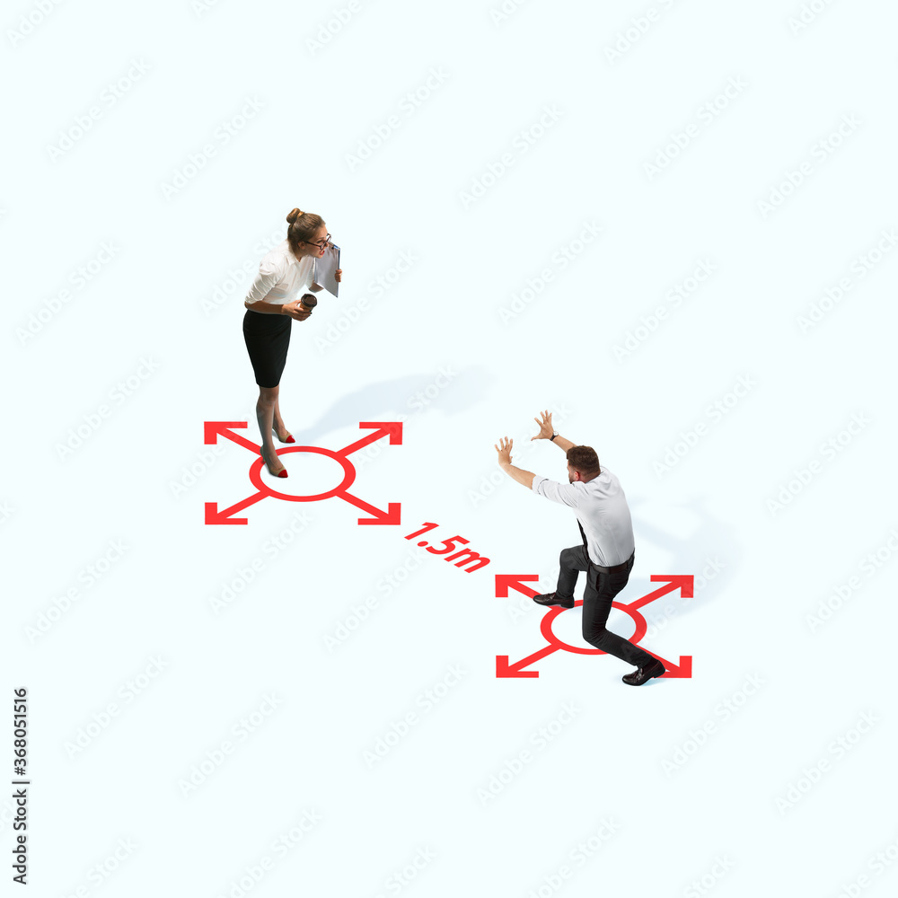 Studio shot of people demonstrating social distancing with arrows indicating the separation. Office workers during coronavirus outbreak with new rules for safety and healthcare. High angle view Studio shot of people demonstrating social distancing with arrows indicating the separation. Office workers during coronavirus outbreak with new rules for safety and healthcare. High angle view