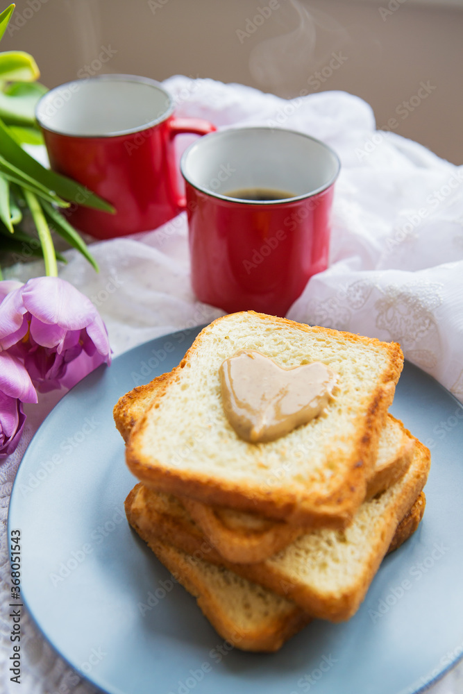Homemade breakfast in bed. Toast with peanut butter, a cup of coffee and tulips. Good morning. Homemade breakfast in bed. Toast with peanut butter, a cup of coffee and tulips. Good morning.