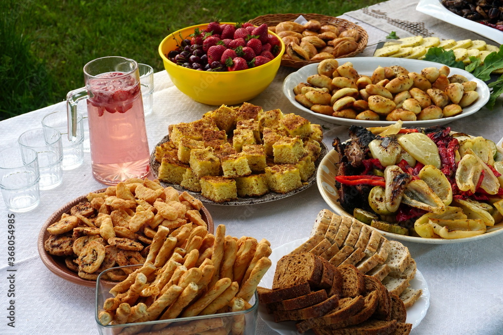 Traditional midsummer festive table with pies, cakes, lemonades and grilled vegetables, Midsummer food table in Latvia Traditional midsummer festive table with pies, cakes, lemonades and grilled vegetables, Midsummer food table in Latvia