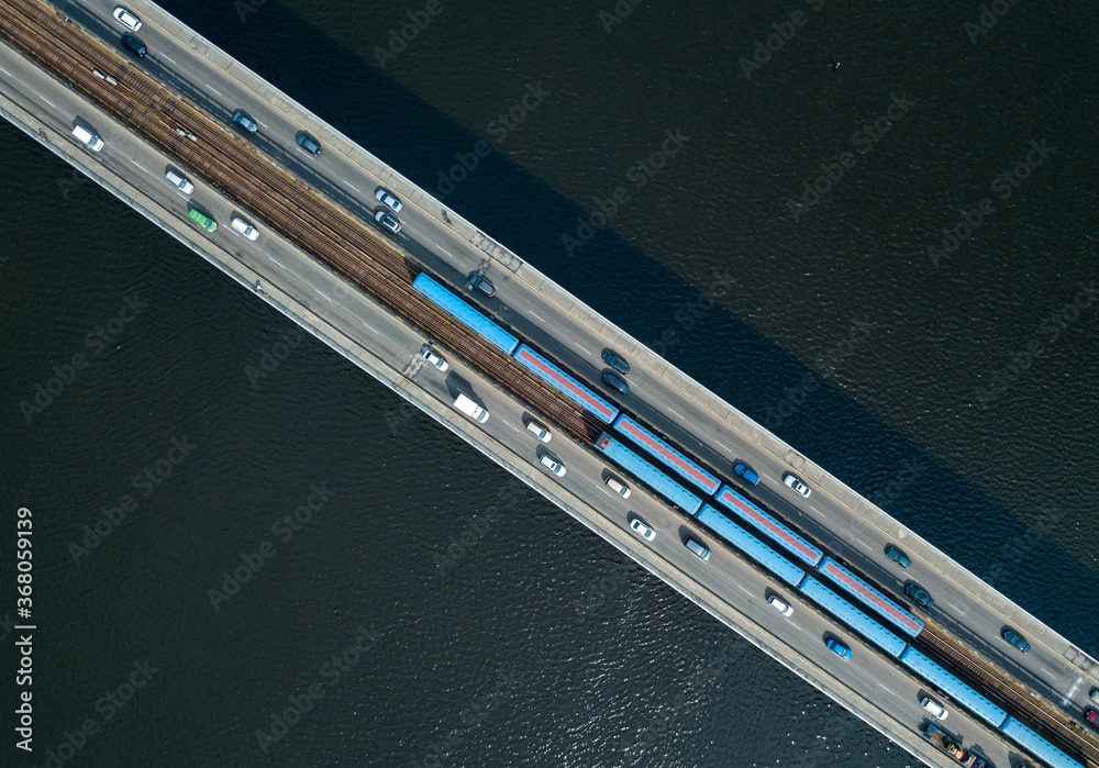 Aerial drone top view. Kiev metro trains travel across the bridge over the Dnieper River. Clear sunny summer day. Aerial drone top view. Kiev metro trains travel across the bridge over the Dnieper River. Clear sunny summer day.