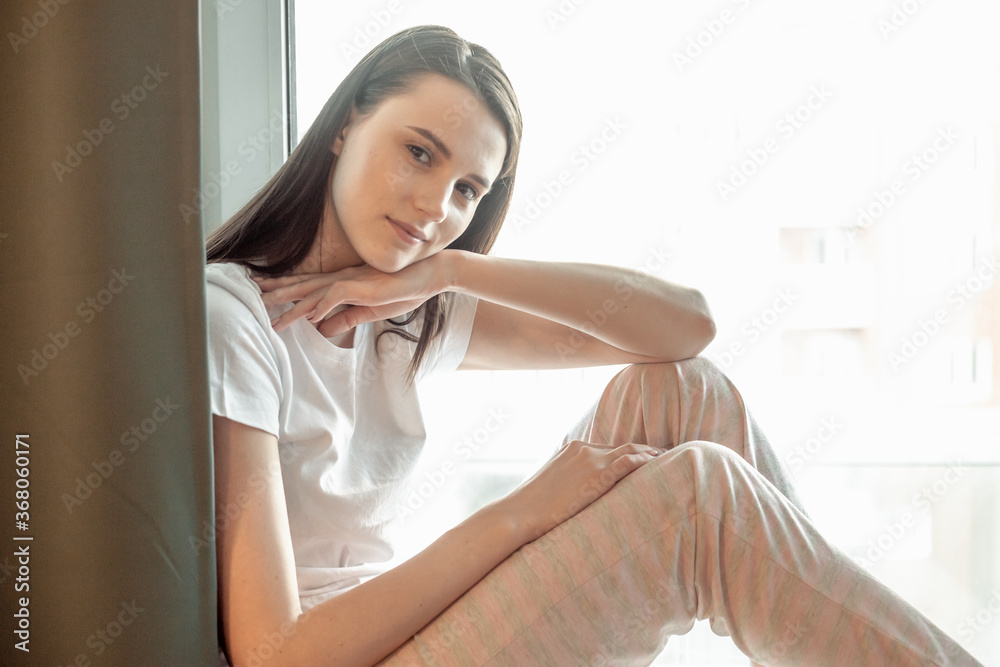 Beautiful young woman portrait behind window