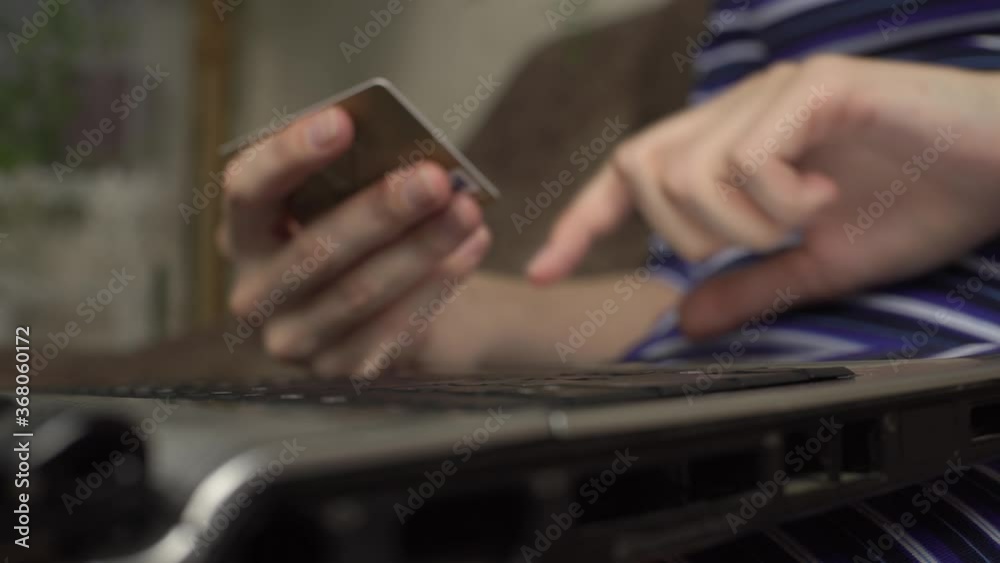 Female hands of cardholder holding credit card making e bank online payment. Woman consumer paying for purchase in web store using laptop technology. Ecommerce website payments concept. Close up view Female hands of cardholder holding credit card making e bank online payment. Woman consumer paying for purchase in web store using laptop technology. Ecommerce website payments concept. Close up view