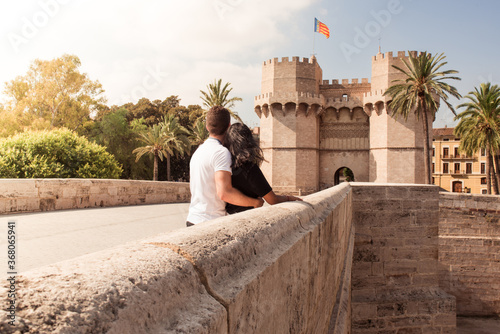 Young couple visiting the city of Valencia looking at the Serrano towers.