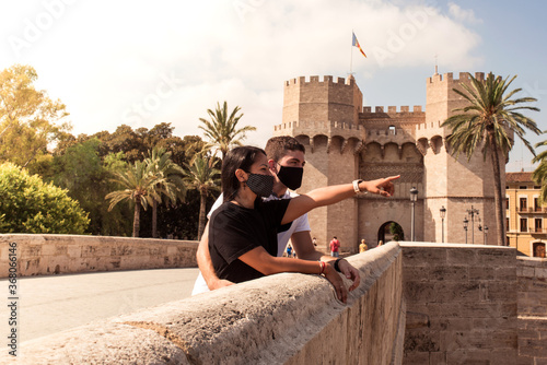 Young couple sightseeing in Valencia with cloth masks to protect from the virus. Tourism concept during the coronavirus in Spain. photo