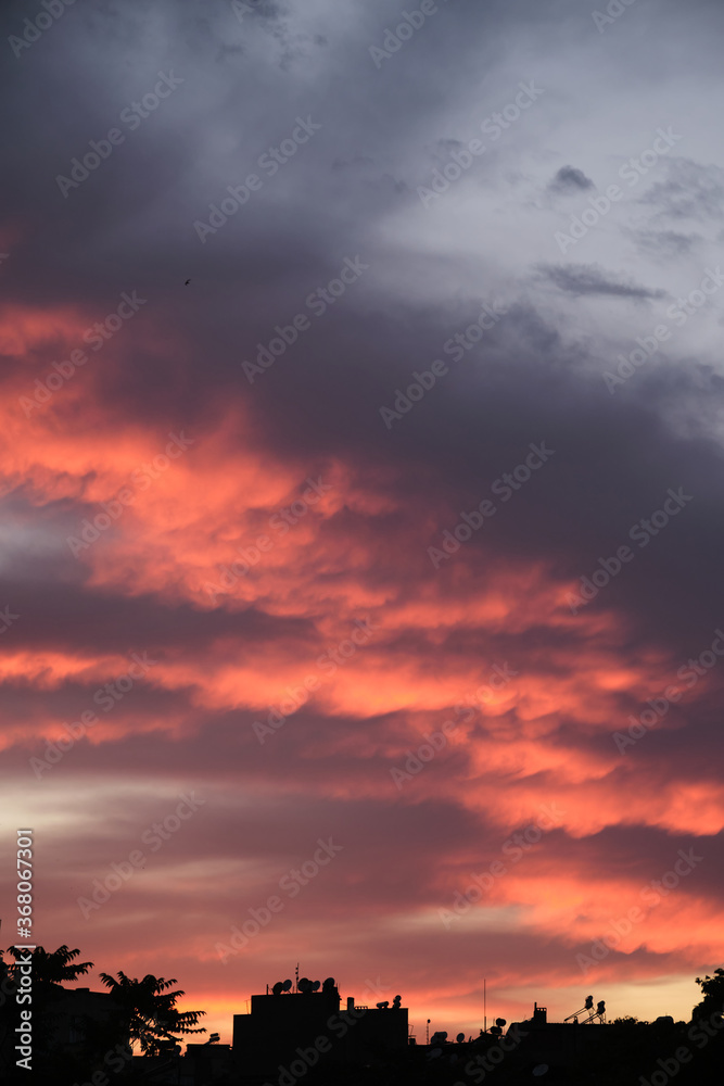Colorful clouds and city silhouette at sunset