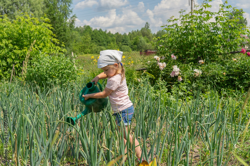 child watering the garden from a watering can