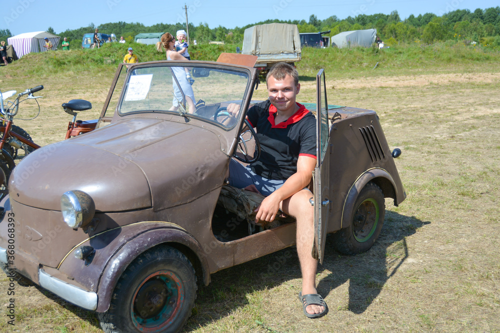 A teenager sits in an old restored car at an exhibition of vintage cars that took place in the summer of 2019 in the city of Kuvshinovo, Tver region