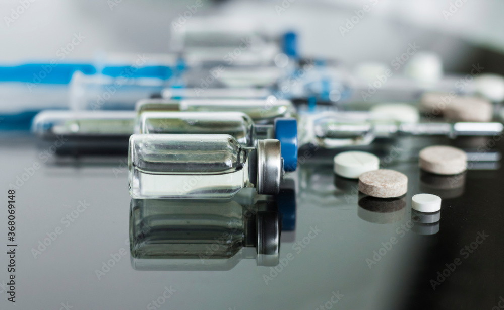Thermometer, pills, injection vaccineampoules, syringe for vaccination on glass background, medicine concept background, Coronavirus quarantine, Covid-19. Thermometer, pills, injection vaccineampoules, syringe for vaccination on glass background, medicine concept background, Coronavirus quarantine, Covid-19.