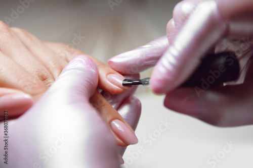  women s hands in pink gloves do manicure   