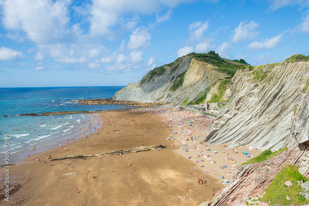 Panoramic view of Itzurun beach, a summer afternoon with blue sky, at low tide, horizontal