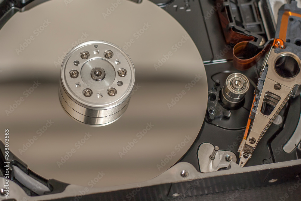 Disassembled hard drive from the computer, hdd with mirror effect. Opened hard drive from the computer hdd with mirror effects. Part of computer pc, laptop. Disassembled hard drive from the computer, hdd with mirror effect. Opened hard drive from the computer hdd with mirror effects. Part of computer pc, laptop.