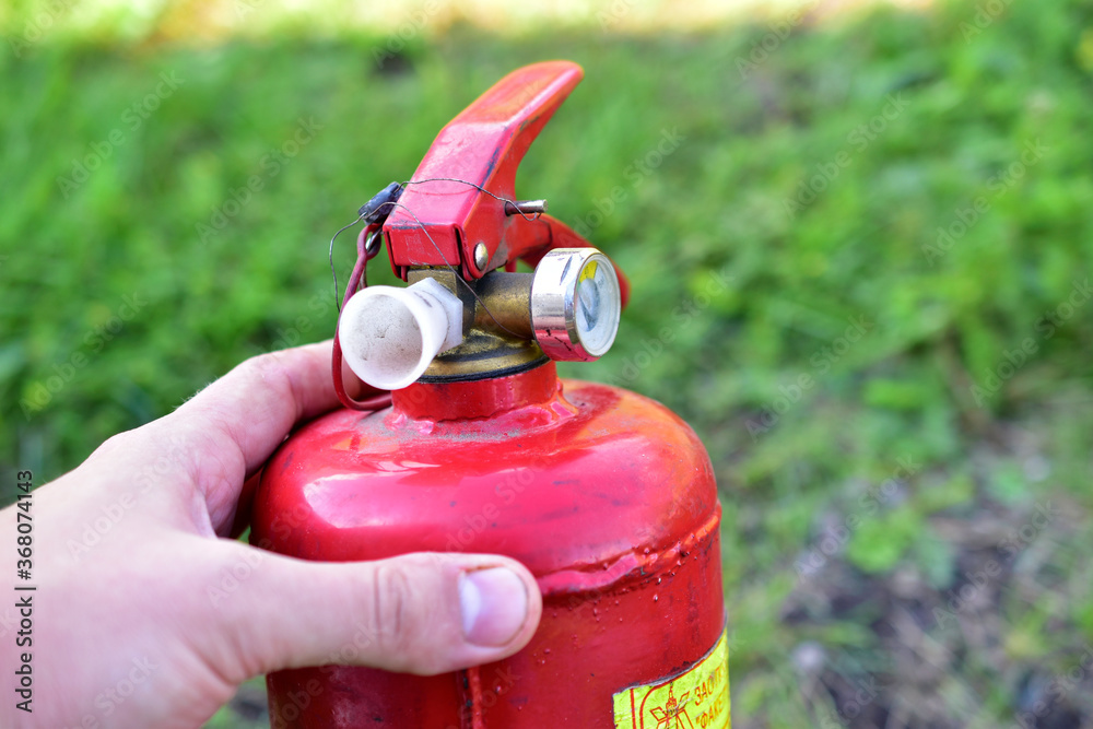 Naklejka premium Red balloon hand extinguisher in the garden