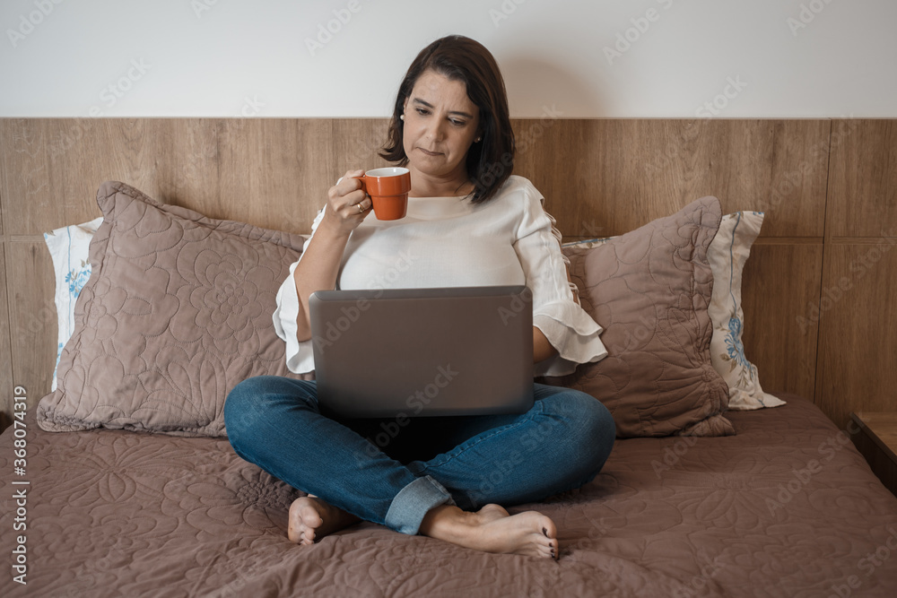 young woman doing home office, holding a cup, with her laptop computer. young woman doing home office, holding a cup, with her laptop computer.