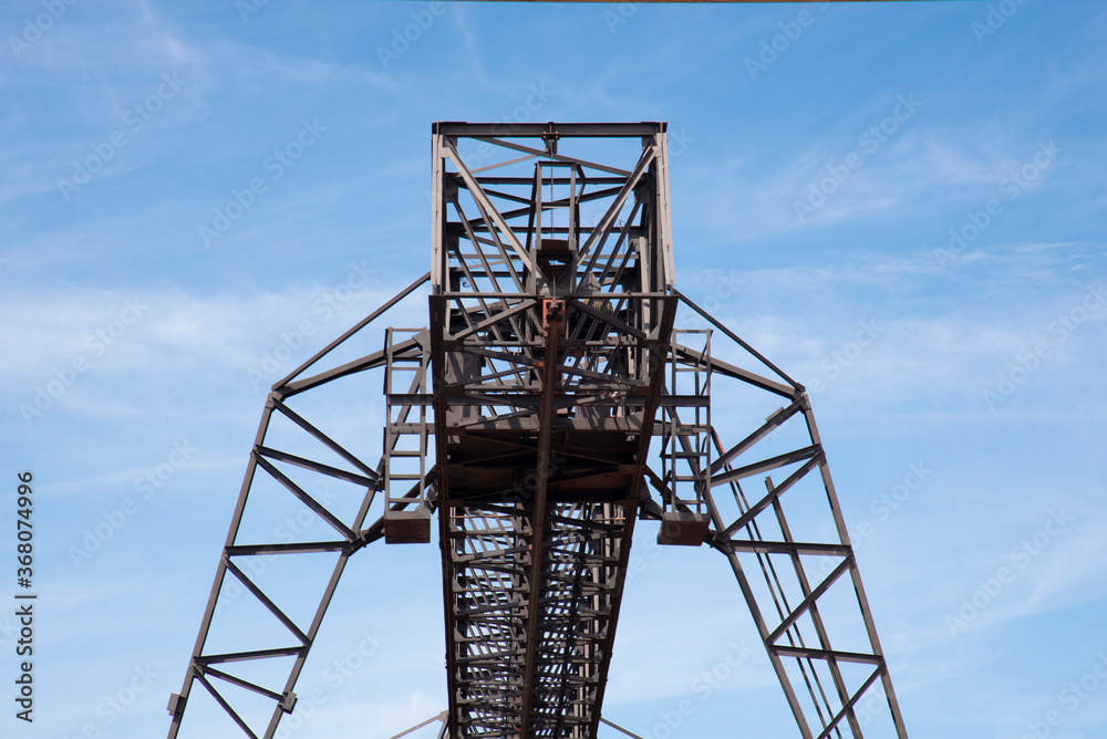 Iron construction against the blue sky. Fragment of the lift. Abstract background.