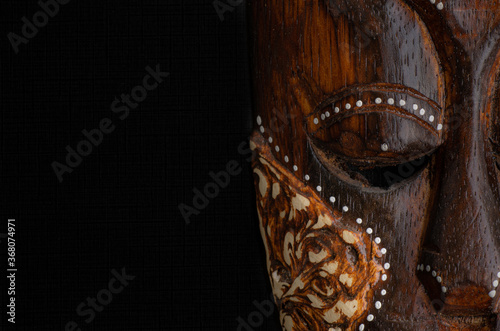 Máscara tribal de madera sobre fondo negro de la isla de Borneo, Indonesia photo