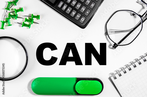 Business concept. On the white table is a calculator, magnifer, green markers, glasses, pins and a notebook with the inscription can. Business Coaching photo