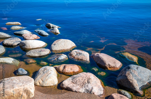 Stones in clear blue lake water. Lake Ladoga, Russia.