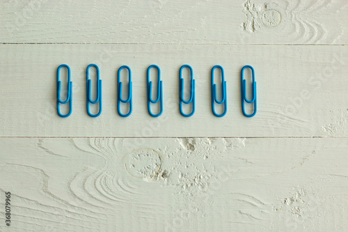 Tableau sur toile blue paperclips on the white background, order on the table and life, psycholog