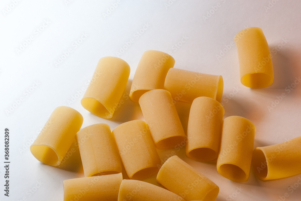 half paccheri macaroni Italian dry raw pasta bronze drawn white background  top view