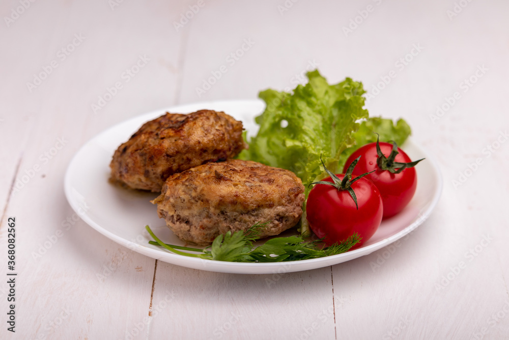 meatballs with tomatoes and lettuce on white background