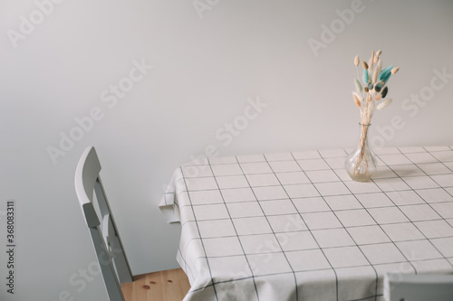 Modern dining room. Table with bouquet of flowers and chairs. Modern kitchen interior. Sunny morning. Cozy home. interior design