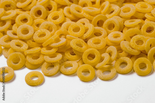 small rings Italian dry raw pasta macaroni bronze drawn white background top view