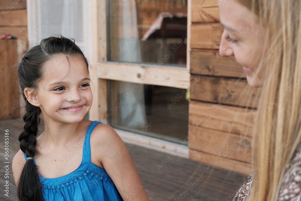 Cute little girl smiling and spending time together with her mother outdoors Cute little girl smiling and spending time together with her mother outdoors